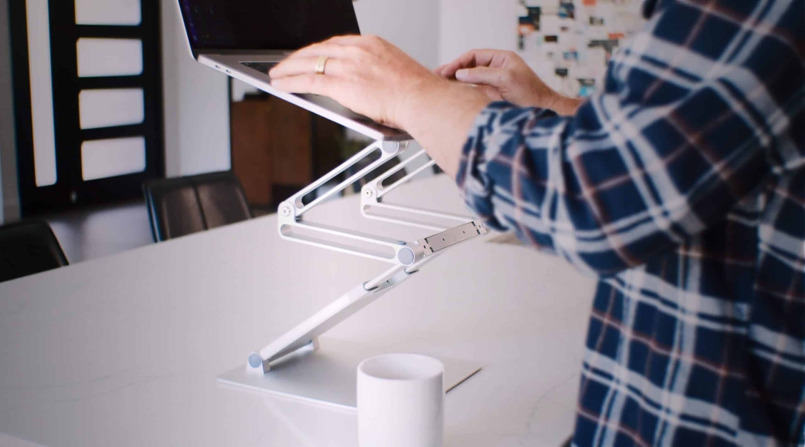 DriftDesk's aluminum build holding a laptop on a conference table