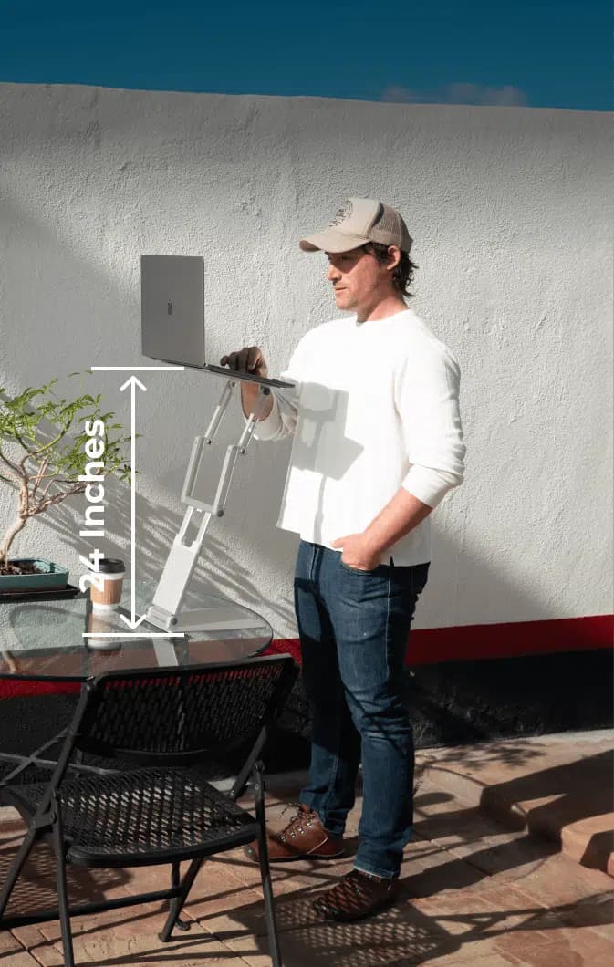 Man working at a DriftDesk raised to full 24-inch standing height outdoors